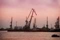 Port docks at sunset. Unloading ships on background of evening sky. Sea port and unloading of cargo containers. Silhouette of dock Royalty Free Stock Photo