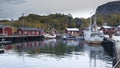 Port of the fishing town of Nusfjord, Norway, Lofoten islands, golden autumn surrounded by colorful mountains and blue water