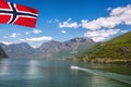 Port of Flam with tourist boat in the fjord with flag of Norway Royalty Free Stock Photo