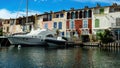 View over water canal on private pier with luxury yachts at resedential building against blue summer sky Royalty Free Stock Photo