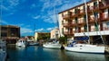 View over water canal on residential house and sail yachts with private pier against blue summer sky