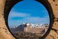 Port-hole view of white, walled city Essaouira, Morocco