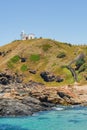 Port Macquarie Lighthouse, white lighthouse on the cliff top, small bay with sandy beach and volcanic rocks, seaside landscape