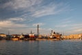 At the port of Mazara del Vallo in Sicily, the port with the shipyard is illuminated golden in the evening sun. There are tender