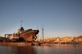 In the port of Mazara del Vallo there is metal ship in a shipyard. The ship\'s propeller sticks out of the water. In