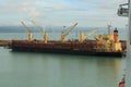 A bulk carrier ship taking on a large cargo of logs