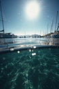 Port with sailing boats, sea, sky and sun created using generative ai technology Royalty Free Stock Photo