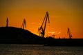 Crane silhouettes skyline in shipyard