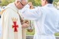 Priest lights incense burner during outdoor catholic procession