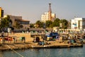 Busy coast in a harbor in Port Sudan, with sudanese people trading goods, exchanging, fishing, spending time and working.