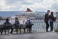 Port of Syracuse. A couple hugging. Some people on the bench.