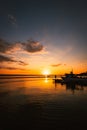 Port of the village of Taranto Vecchia at dawn with silhouettes of fishermen