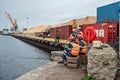 Port workers at leisure time with fishing rod catch fish the port canal