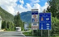 Traffic signs on the border between Austria and Germany and mobilhome in the back.