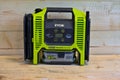 portabel Ryobi airpump with battery standing on wooden bench