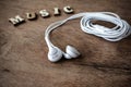 Portable audio earphones on old wood textured Royalty Free Stock Photo
