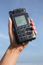 Portable audio recorder in hand recording ambient sounds