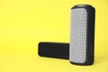 Portable bluetooth speakers on yellow background, space for text. Audio equipment