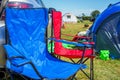 Portable camping chairs over blue family tent in holiday park