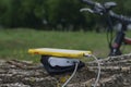 A portable charger charges the smartphone. Power Bank with cable against the background of wood and bicycle Royalty Free Stock Photo