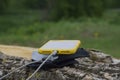 A portable charger charges the smartphone. Power Bank with cable against the background of wood and bicycle Royalty Free Stock Photo