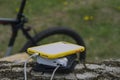 A portable charger charges the smartphone. Power Bank with cable against the background of wood and bicycle Royalty Free Stock Photo