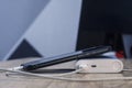 A portable charger charges a smartphone on a wooden table. Power bank with phone and cable on the background of the monitor