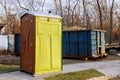 Portable chemical toilets for construction new house and dumpster full garbage