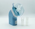 Portable compressor nebulizer on white table. Medical equipment for inhalation therapy, asthma, bronchitis