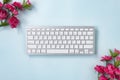 Portable Computer Keyboard and Rose Flower at Top Left and Bottom Right Corner Royalty Free Stock Photo