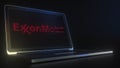 Portable computer with the logo of EXXON MOBIL made with code strings, editorial conceptual 3d rendering
