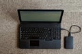 Portable computer and USB drive on a light textured background.