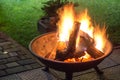 A portable fireplace with bright burning firewoods making sparks