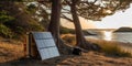 Portable foldable solar panel battery hanging on pine tree on seashore near sandy beach , concept of Renewable energy Royalty Free Stock Photo