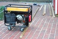 Portable Generator with wheels on the House Construction Site. Close up on Mobile Backup Generator. Royalty Free Stock Photo