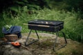 portable grill with charcoal and tongs in minimalist outdoor setting