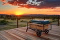 portable grill on wooden deck with serene view of the sunset