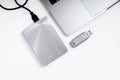 Portable hdd connected to a laptop and a usb flash drive on a grey background, flat lay. Data storage concept Royalty Free Stock Photo