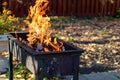 Portable metal grill with burning wood and red fire. Barbecue on the street. Fire and charcoal grilled. Royalty Free Stock Photo