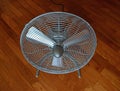 Portable mini blower floor fan on diagonal parquet flooring