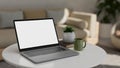 Portable notebook laptop mockup on coffee table in modern comfortable living room Royalty Free Stock Photo