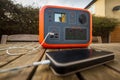 Portable power station solar electricity generator with mobile phone plugged in charging.