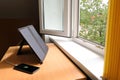 Portable solar charger on table near the window charges the smartphone