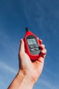 Portable thermometer in hand measuring outdoor air temperature and humidity Royalty Free Stock Photo