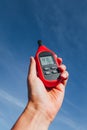 Portable thermometer in hand measuring outdoor air temperature and humidity