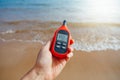 Portable thermometer in hand measuring outdoor air temperature and humidity Royalty Free Stock Photo