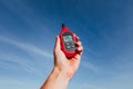 Portable thermometer in hand measuring outdoor air temperature and humidity Royalty Free Stock Photo