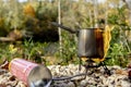 Portable tourist gas stove with a gray kettle on a background of nature in the mountains. Camping kitchen and tea Royalty Free Stock Photo