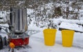 Portable travel gas stove with a cup in the snow in winter. Traditional cuisine and tea making. Royalty Free Stock Photo