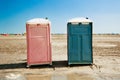 Portable unisex toilets on the beach.